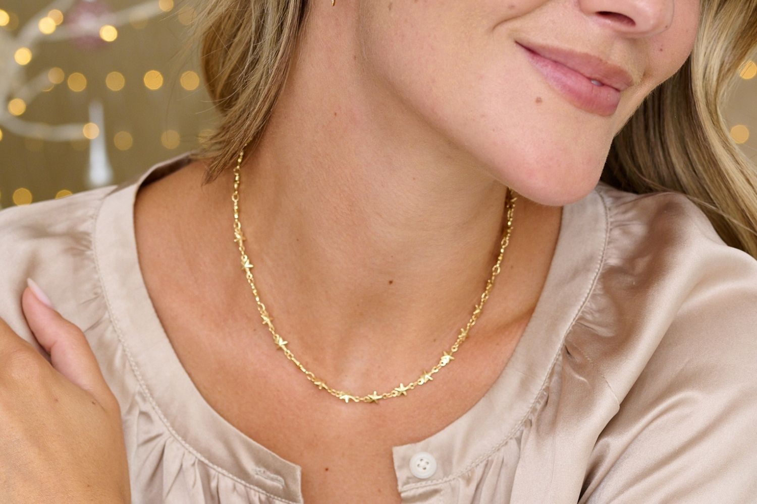 Lifestyle picture showing the chic Delos multi star gold plated necklace