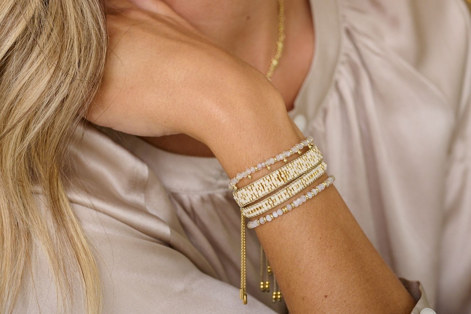 Aslan Gold & Cream Beaded Friendship Bracelet styled on the wrist, showcasing soft cream beads and shimmering gold accents, perfect for adding everyday elegance.