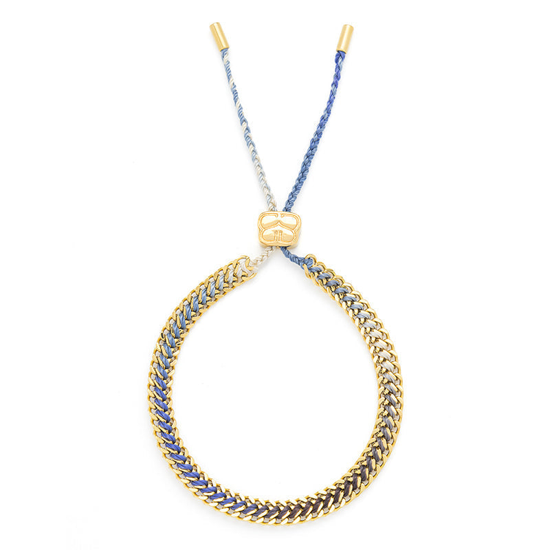 Athena Denim Gold Braided Bracelet with blue ombre thread and 14k PVD gold-plated curb chain, perfect for adding a touch of beachy boho style to your everyday look.