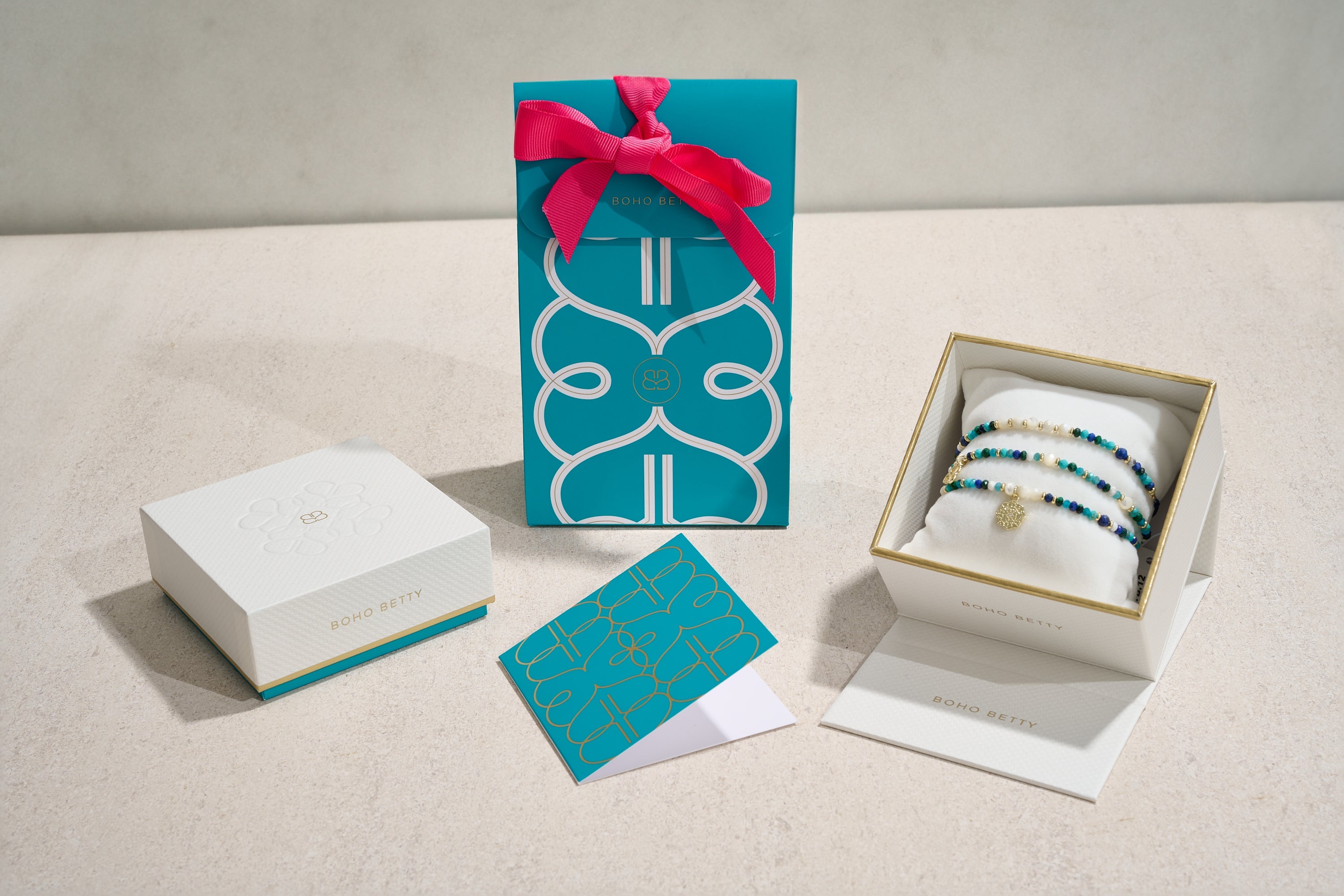 Boho Betty turquoise gift packaging, luxury jewellery box with gold accents, and beaded bracelets displayed for gifting.