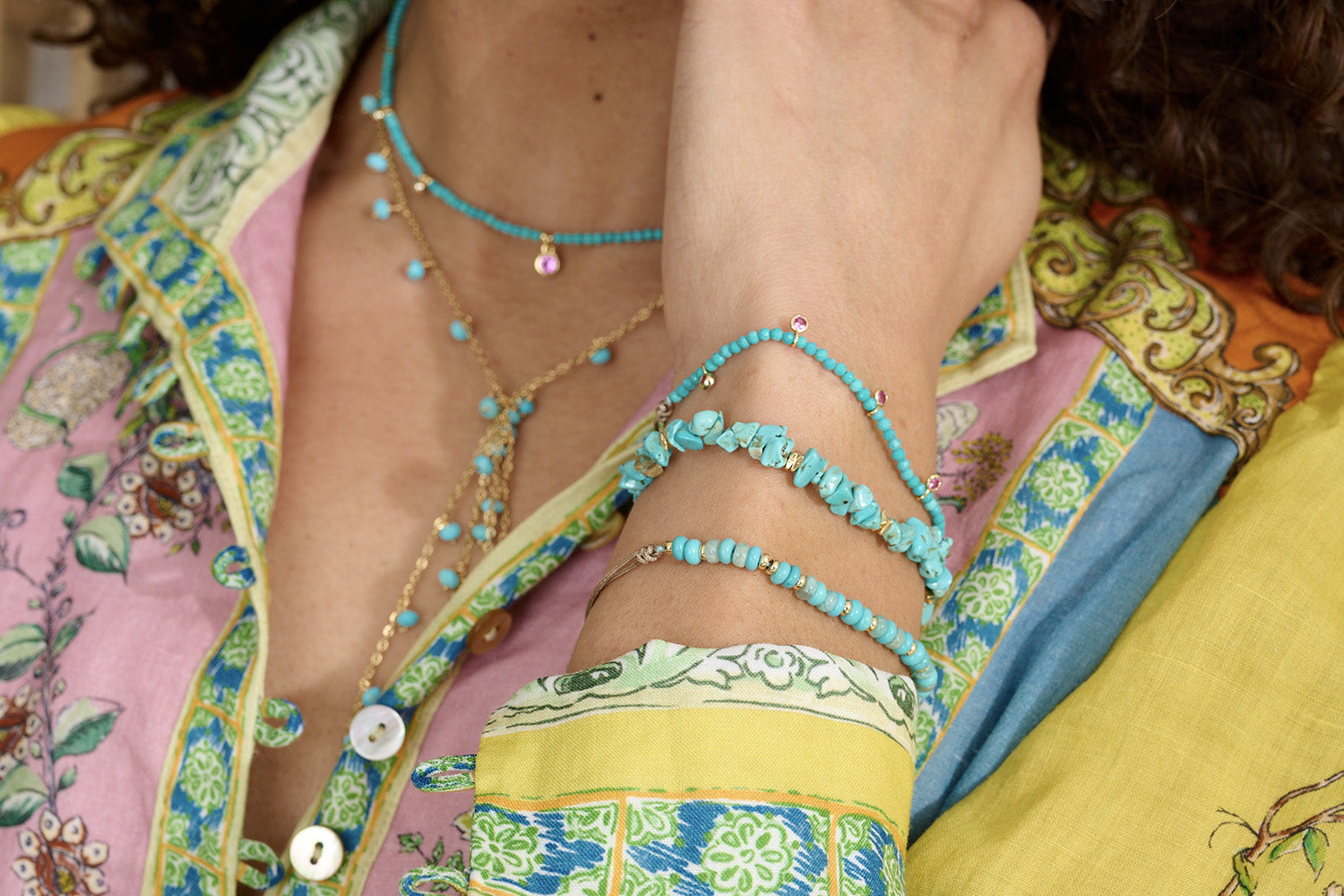 Holly Turquoise Howlite & Pink Crystal Charm Bracelet styled on the wrist, featuring turquoise howlite beads and gold accents, perfect for layering or wearing solo.