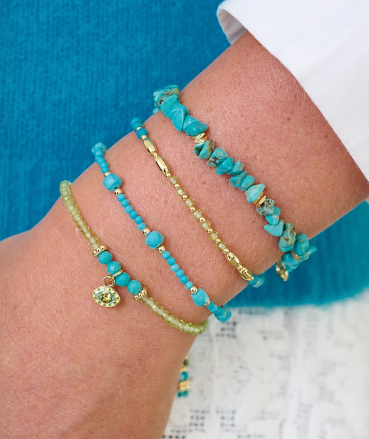 Nassau Peridot and Turquoise Gold Stacking Bracelet styled on the wrist, showing vibrant turquoise and peridot gemstones with golden accents for a tropical chic look.